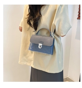 Détail du sac à bandoulière en PVC bleu transparent avec rabat en tissu gris et serrat