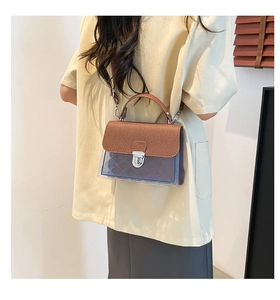 Détail du sac gelée bleu translucide avec rabat marron texturé et fermoir rotatif argent