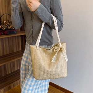 Large straw tote bag with rope handles and lace bow detail for summer style