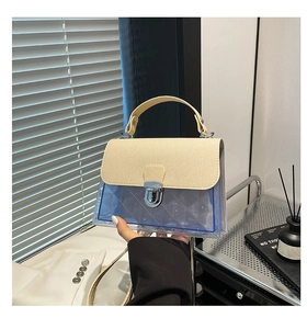 Détail du petit sac carré bicolore avec corps en PVC et rabat en cuir grainé
