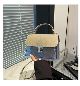 Détail d'un sac bandoulière en PVC bleu transparent avec poignée tressée et serrure
