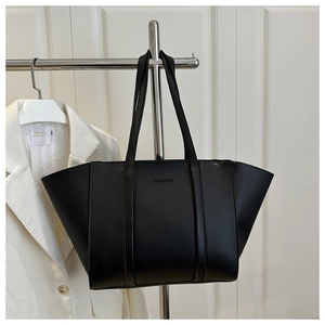 Detail of black leather tote bag with embossed Fashion logo and dual shoulder straps