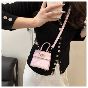 Detailed mirror selfie showing a pink croc-embossed mini crossbody bag with metal lock