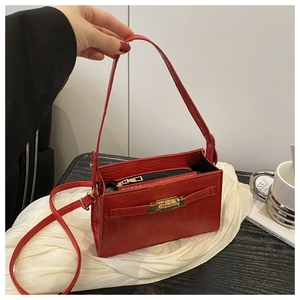 Detailed view of red crocodile texture PU leather handbag with golden metallic clasp