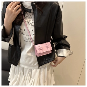 Close-up of pink mini crossbody bag with double buckle flap on a leather jacket