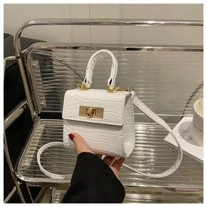 Detailed close-up of a white faux leather mini bag with crocodile texture and gold clasp