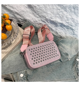 Détail du sac bandoulière rose avec strass brillants et rivets argentés sur veste en jean