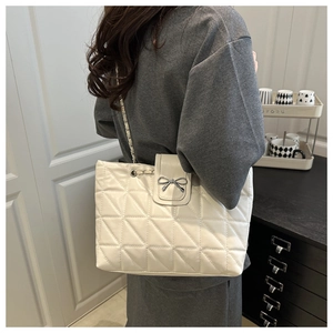 Détail du sac bandoulière matelassé blanc avec fermoir nœud argenté et chaîne métal