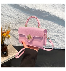 Detailed shot of pink textured mini bag featuring flower clasp and spiral handle