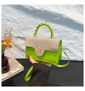 Detail of neon green leather bag with woven flap and gold flower twist lock