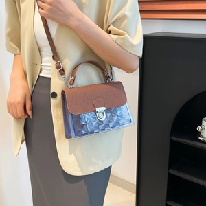 Sac à bandoulière bleu transparent chic avec rabat marron porté par un mannequin