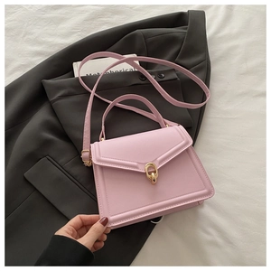 Detailed close-up of a pink leather handbag with elegant gold buckle and fine stitching