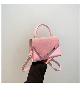 Close-up of pink crossbody bag with rhinestone flap and gold metal trim detailing
