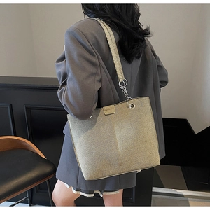 Detailansicht der großen Metallic-Tasche mit gewebter Textur und silbernem Ringverschluss