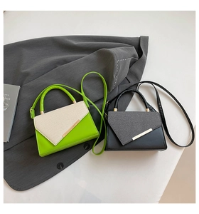 Detail of color-block flap bags with golden metal bars in lime green and black