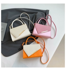 Detailed display of trapezoidal crossbody bags in white, pink, and orange with gold metal buckles