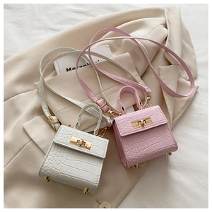 Detail of mini square bags with crocodile texture and elegant gold metallic turn-lock