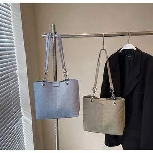 Detail von minimalistischen Tragetaschen in Hellblau und Khaki an einer Kleiderstange