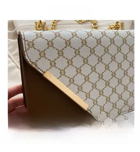 Detailed view of vintage patterned shoulder bag with gold chain and metal trim