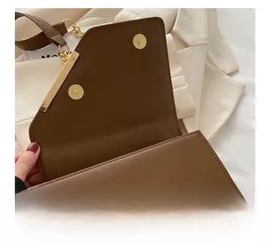 Macro detail of caramel brown leather shoulder bag featuring a gold metallic buckle closure