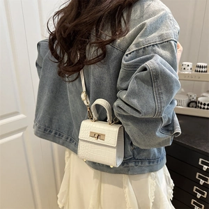 White faux crocodile leather mini square bag with metal clasp shown in hand and on shoulder