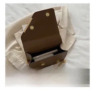 Detail showing the internal capacity of the dark brown leather shoulder bag with gold chain