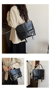 Detailed view of black matte leather tote bag featuring two front pockets with metal buckles