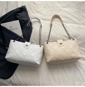 Close-up of diamond-quilted faux leather tote bag with elegant chain strap and metal turn-lock