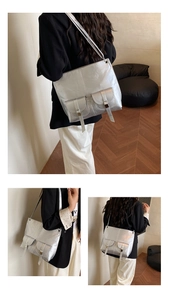 Detailed view of silver metallic oversized tote bag with dual front flap buckle pockets