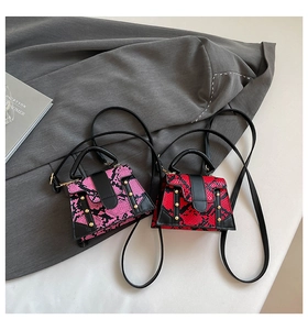 Top view of red and pink snakeskin pattern mini handbags with gold rivets and black straps
