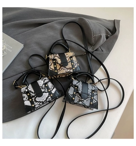 Detailed top view of three snake print crossbody bags with chic metal stud accents