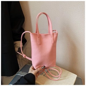Detail of a pink pebbled leather vertical tote bag with handles and thin shoulder strap
