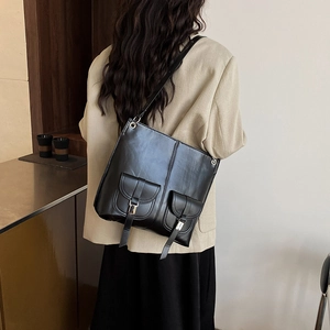 Sac à bandoulière noir en cuir PU avec poches à boucles porté par un mannequin
