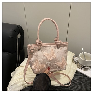 Detailed view of pink floral lace handbag featuring 3D butterfly embroidery and knot handle