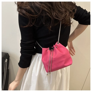 Détail du mini sac seau rose à motif croco avec bandoulière chaîne argentée