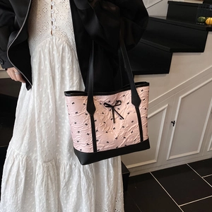 Pink quilted tote bag with black bow patterns and large ribbon for summer daily use