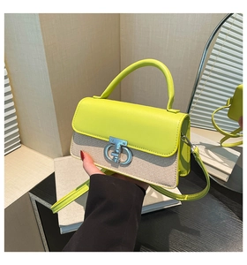 Detail of lime green leather and woven canvas handbag with metallic lock and shoulder strap