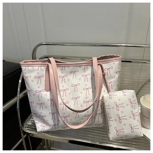 Detail view of floral bow print tote bag set with matching pouch on a steel rack