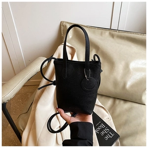 Close-up of black lychee grain mini bucket bag with dual handles and slender strap