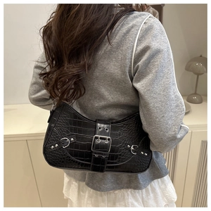 Detail of black faux leather shoulder bag with crocodile texture and silver buckle