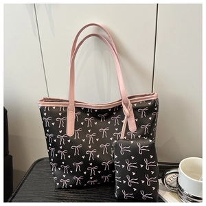 Détail d'un ensemble de cabas à fleurs avec nœuds roses et pochette assortie sur bois