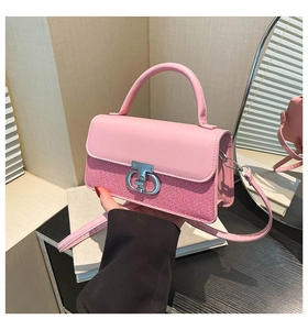 Detail of pink patchwork crossbody bag with woven texture and silver metal twist lock