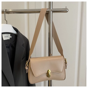 Detailed view of beige faux leather shoulder bag with unique wave edge and golden lock