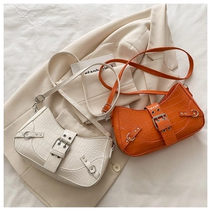 Close-up of retro crocodile pattern shoulder bags with vintage metal buckle and rivet details