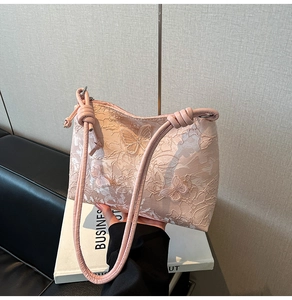 Détail du sac cabas en dentelle rose avec broderie papillon et fines lanières en cuir