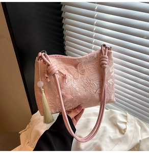 Détail du sac cabas rose en jacquard avec broderie papillon et pompon perlé