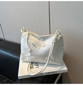 Détail du sac à main en dentelle brodée blanche avec papillons 3D et fines bandoulières