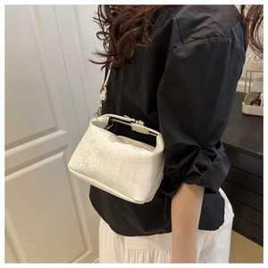 Detail of white snake-textured handbag showing leather grain and detachable strap