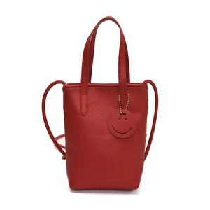 Red lychee grain leather tote bag with smile pendant and adjustable shoulder strap
