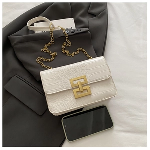 Detail of white crocodile texture crossbody bag with gold buckle and leather chain strap